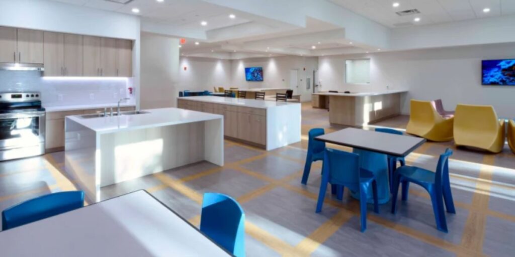 A modern apartment kitchen and dining area with durable, infection-resistant furniture for behavioral health and medical office settings.