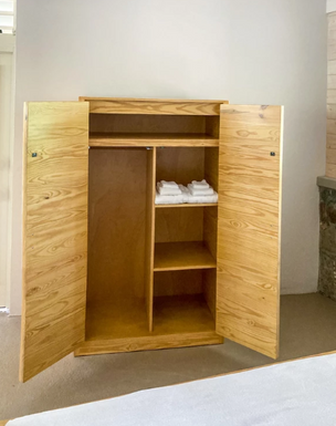 Wooden wardrobe with shelves inside a Cinnamon Bay cottage